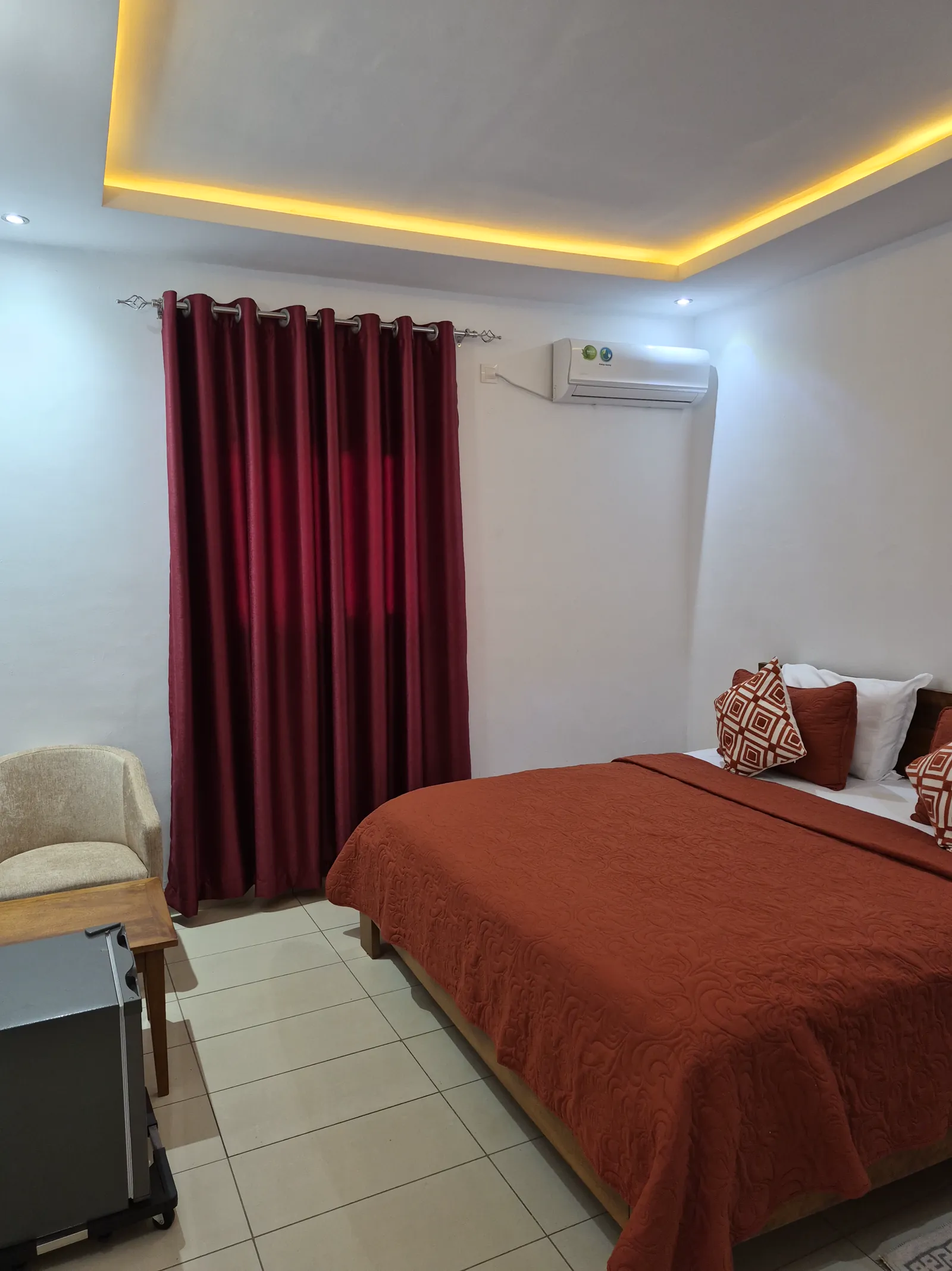 Chambre Deluxe du Dehaly Hôtel, lit grand format, dessus-de-lit terracotta, rideaux bordeaux