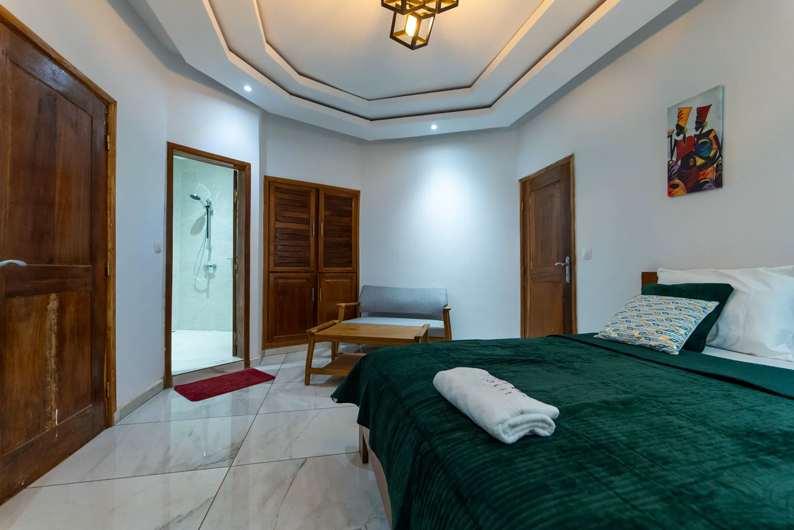 Chambre Exécutive du Dehaly Hôtel, lit grand format, sol en marbre, coin salon